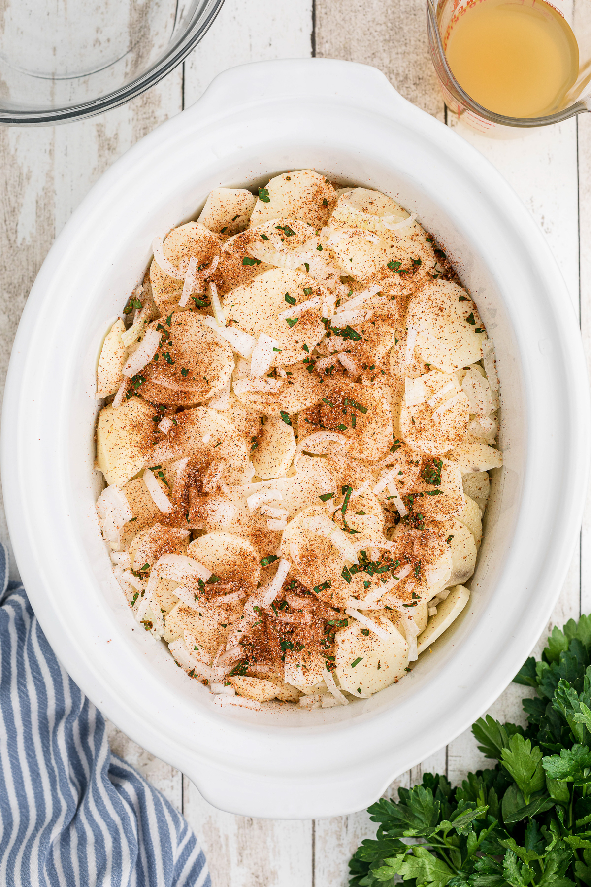 sliced potatoes and onions on top of beef and cheese.