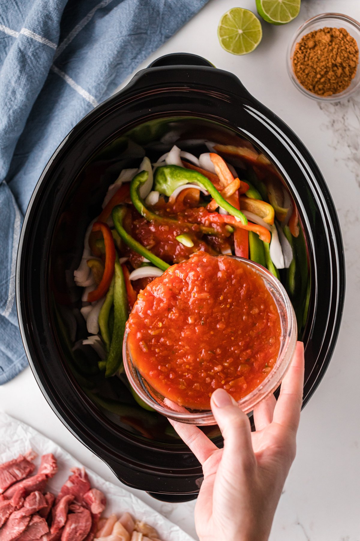 Adding salsa to a slow cooker.