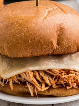 Close up of a chicken sandwich with marinara and mozzarella cheese.