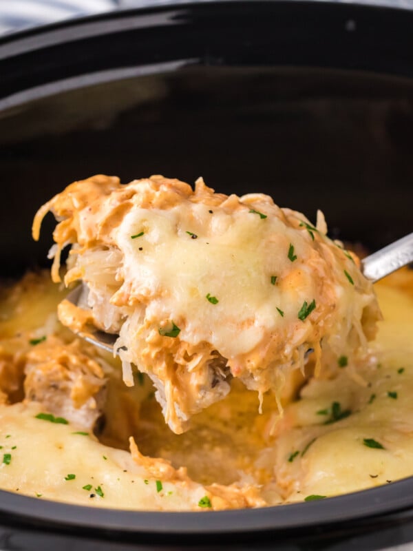 Scooping out some slow cooker chicken reuben casserole.