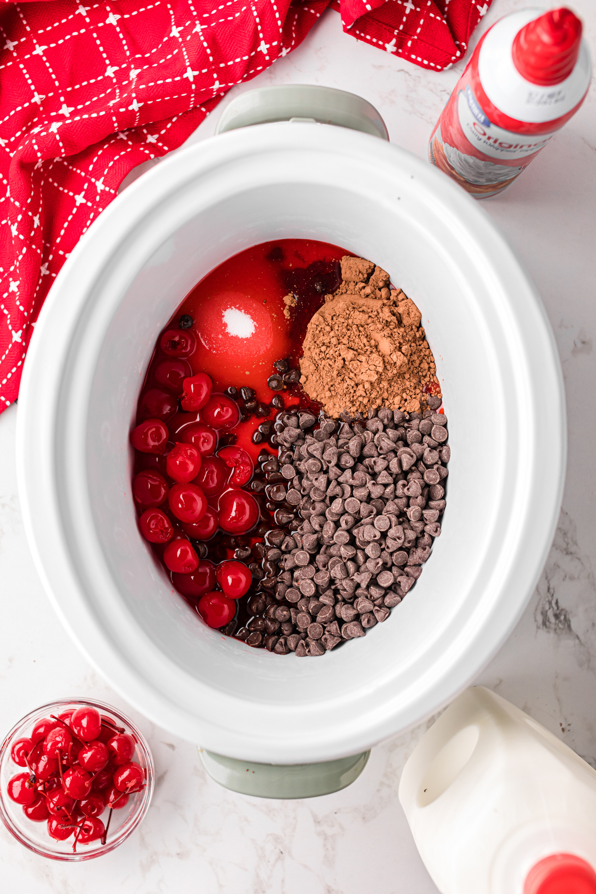 Ingredients for slow cooker chocolate covered cherry hot chocolate in a crockpot.