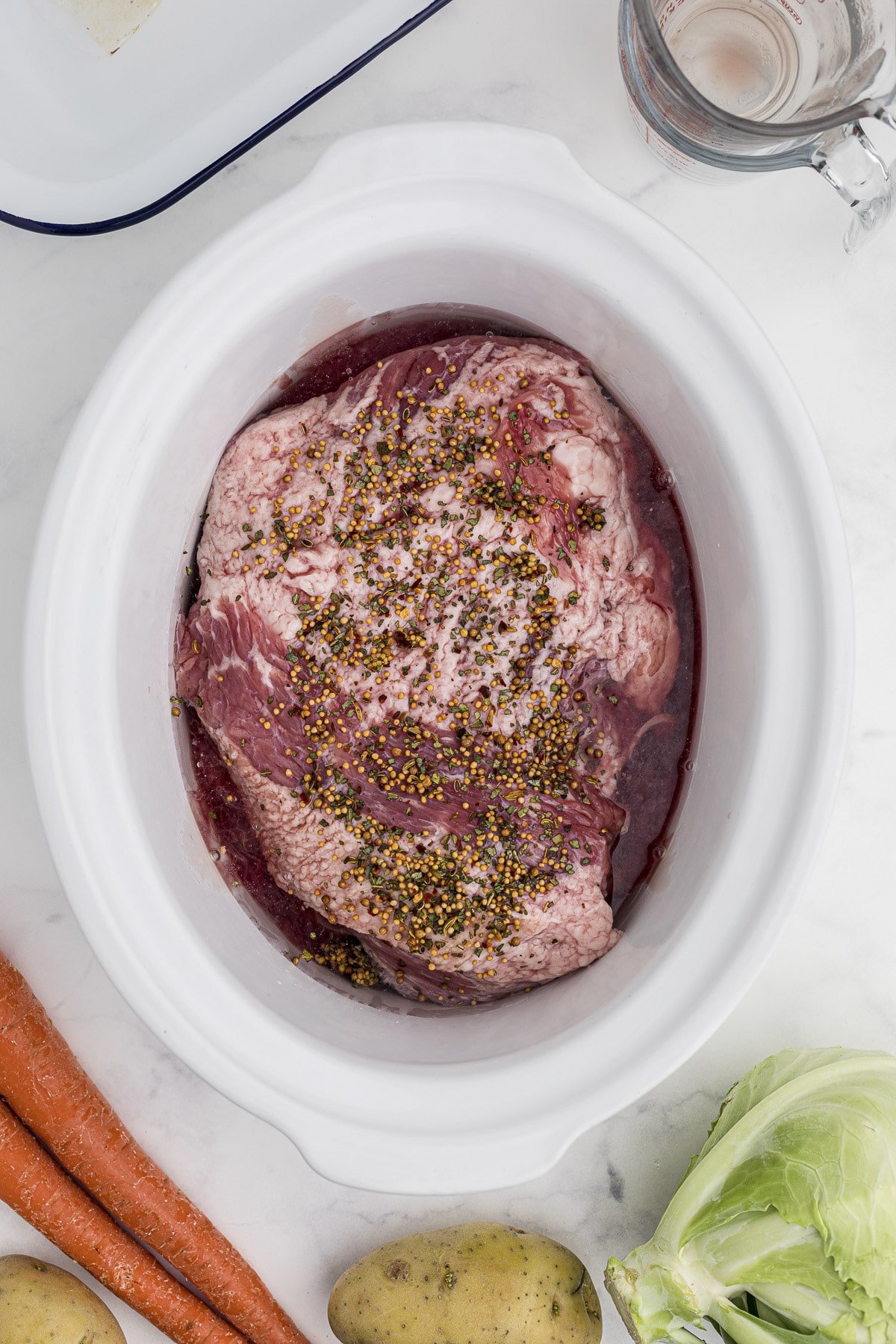 corned beef in the crockpot with seasoning packet over it.