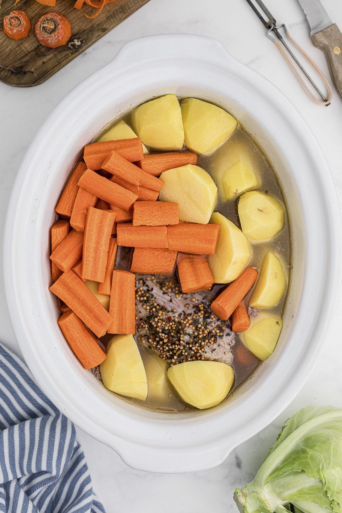 water, potatoes and carrots added on top of corned beef.