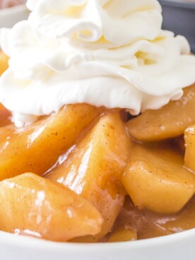 close up of fried apples with whipped cream