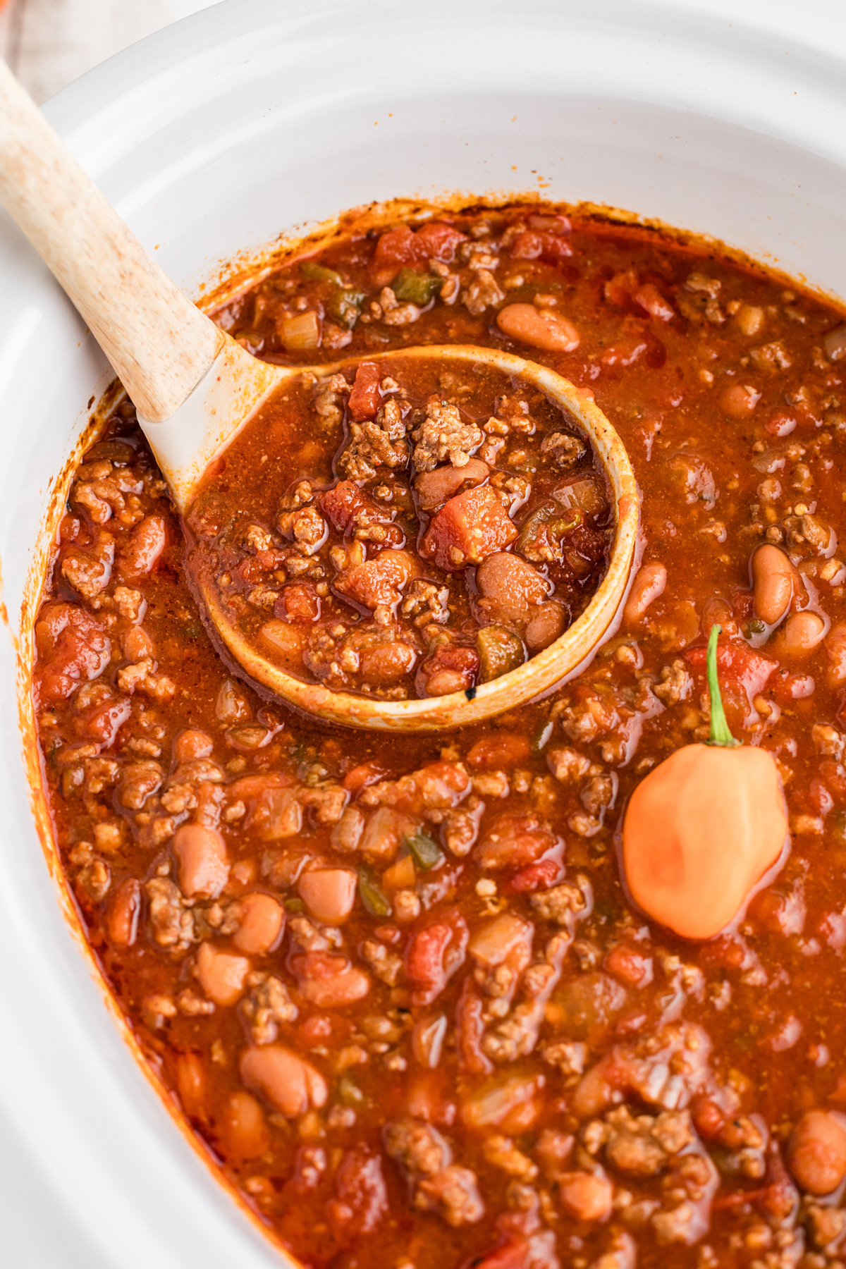 Slow cooker habanero chili with a ladle scooping some out.