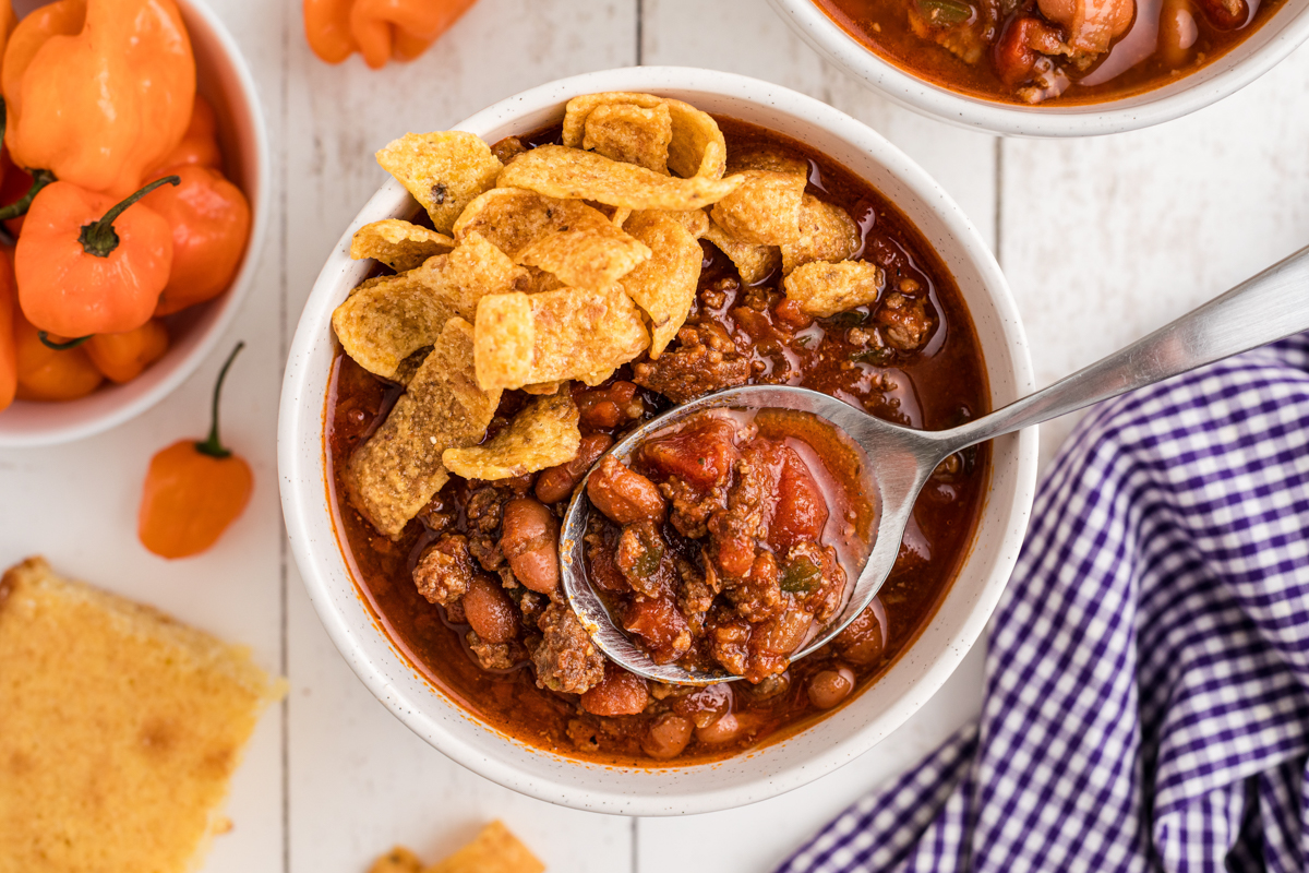 A bowl of slow cooker habanero chili with a spoon in it.