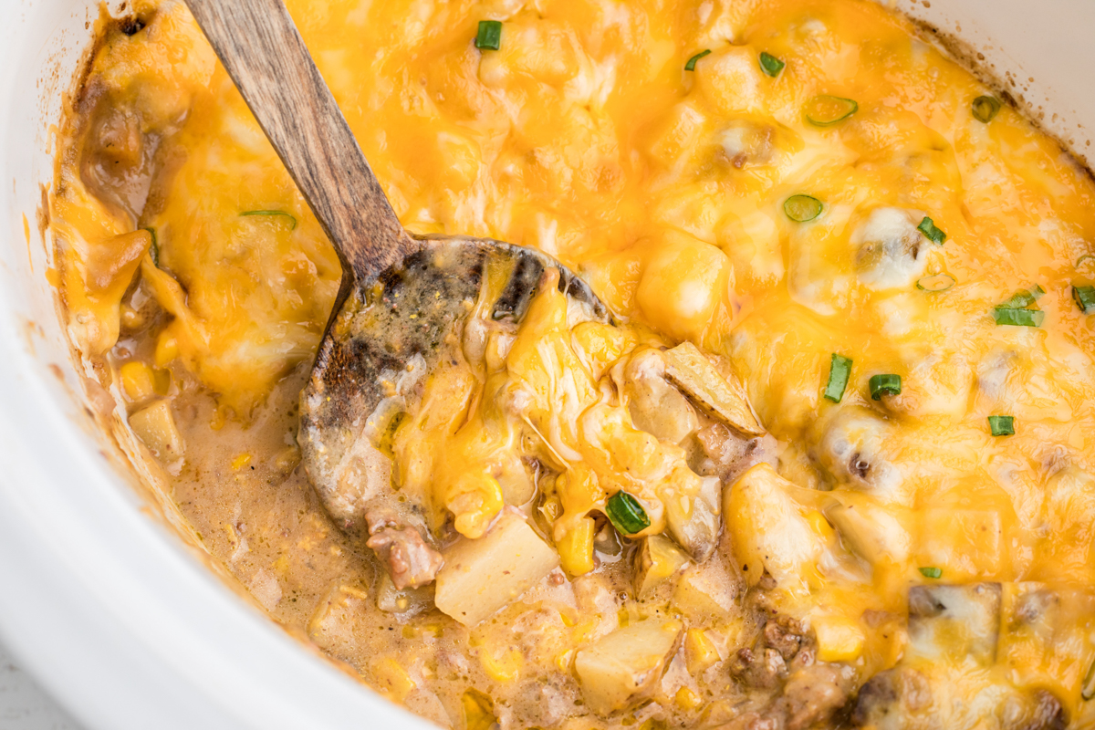 cooked hamburger hash in a white slow cooker.