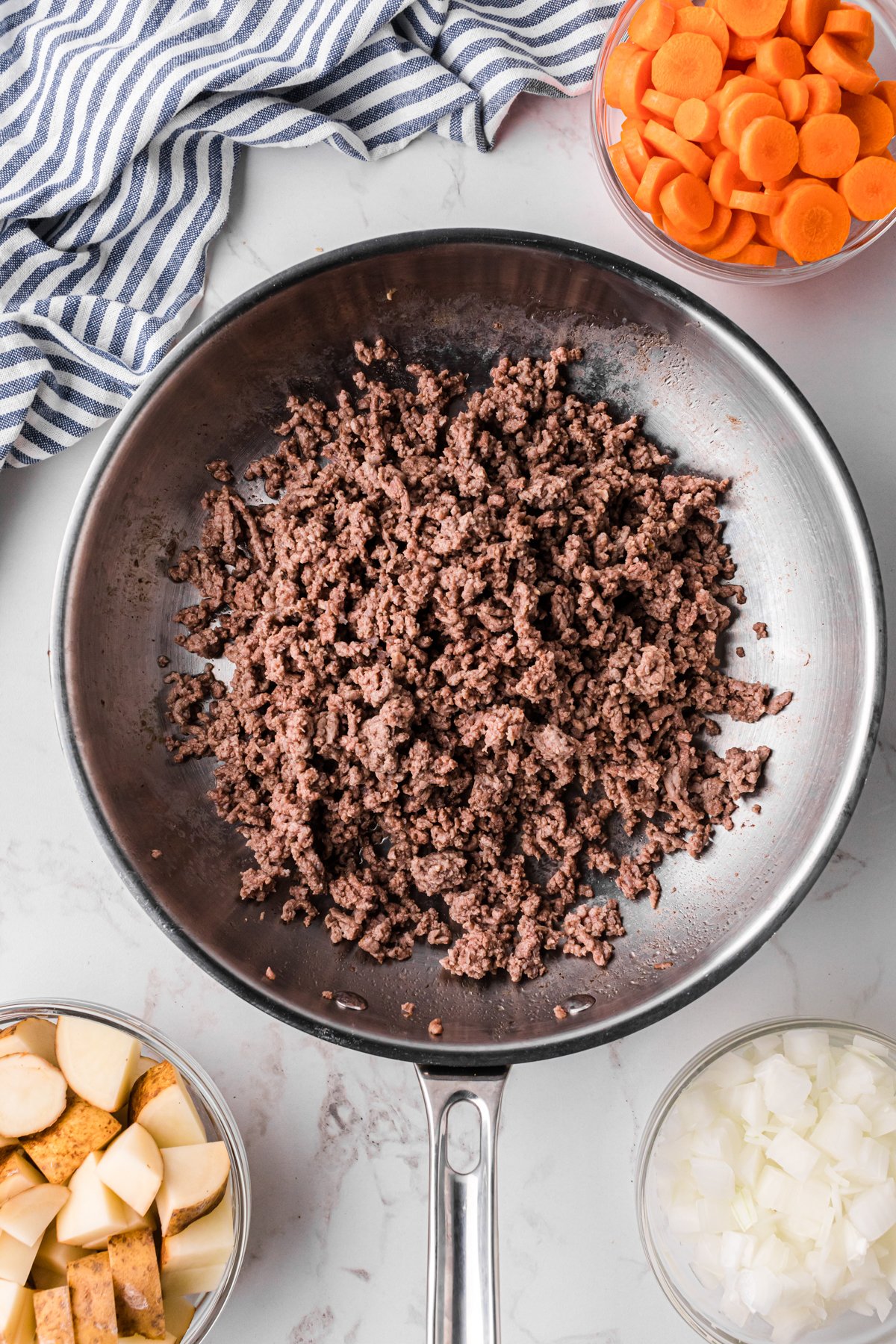 Ground beef cooking in a skillet.