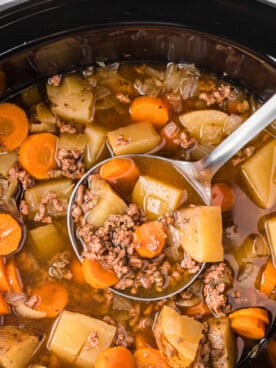 Close-up of ladle scooping out some slow cooker hobo soup.