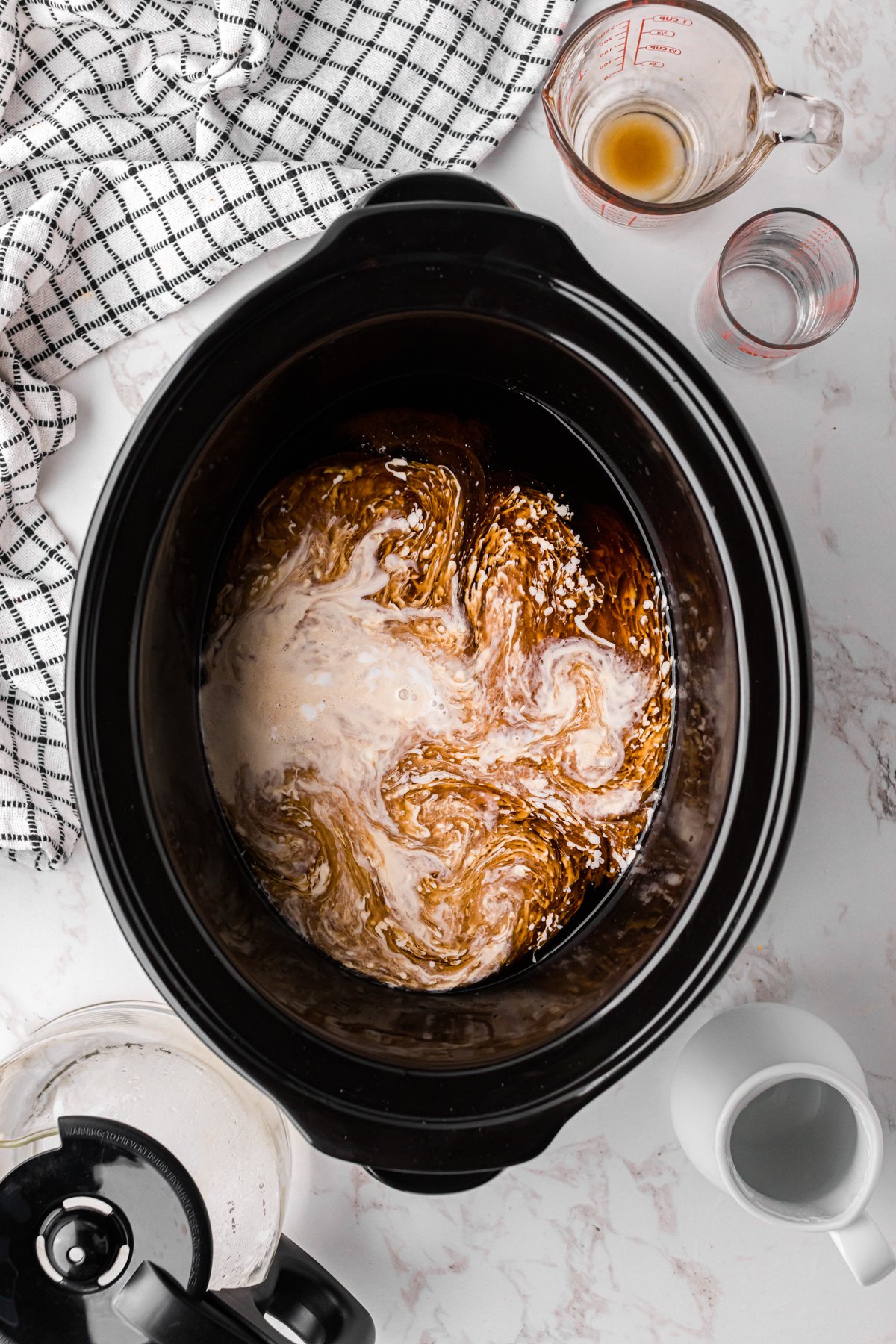 ingredients for slow cooker hot white russians in a crockpot.