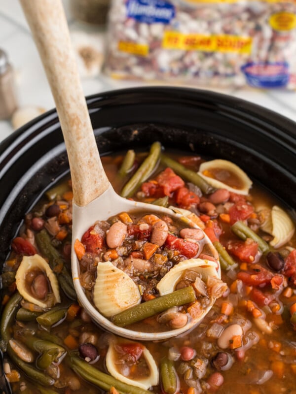 Minestrone 15 bean soup in a slow cooker with ladle.
