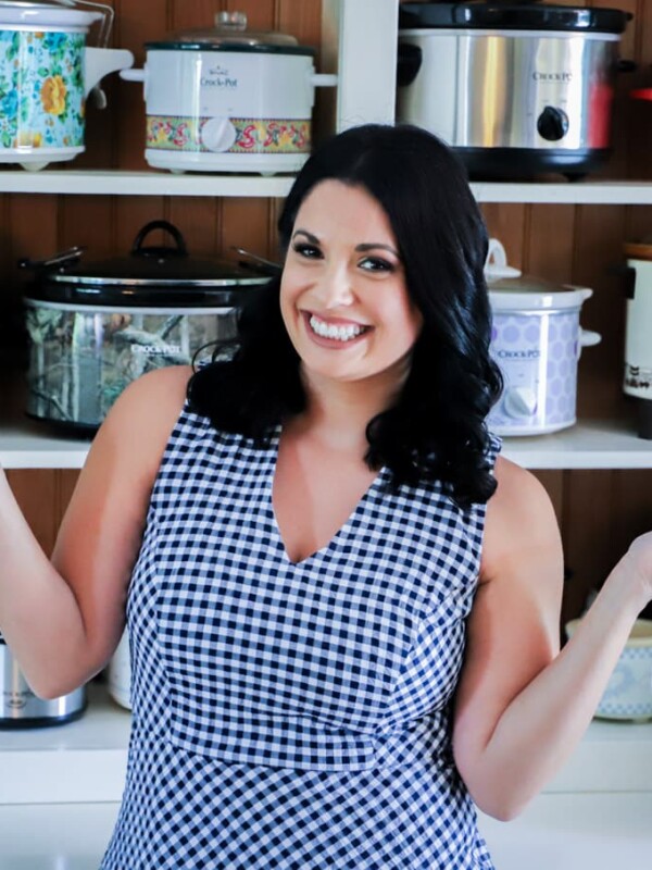 A woman standing in front of shelves full of slow cookers.
