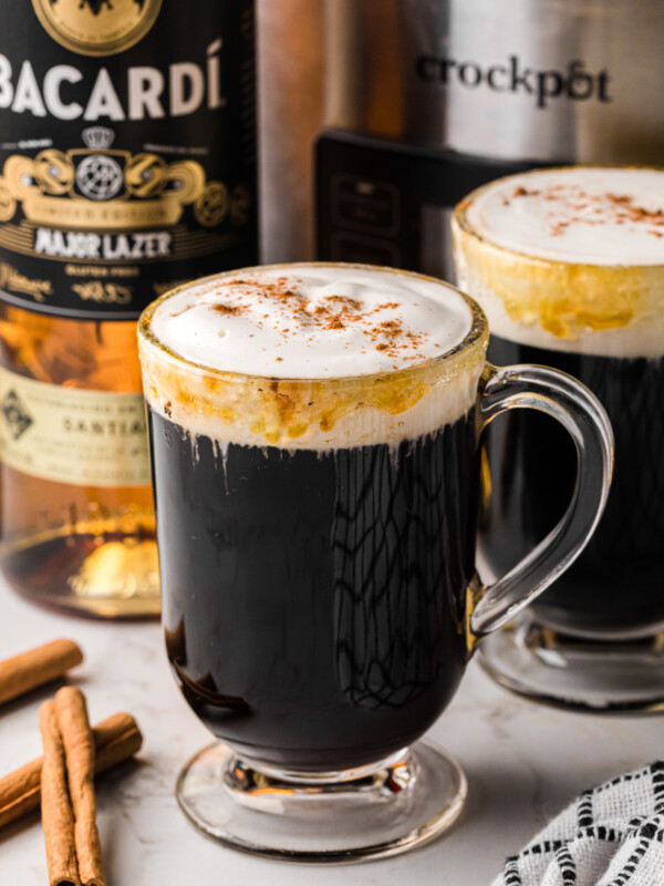 Slow cooker spanish coffee in a glass mug with another behind it.